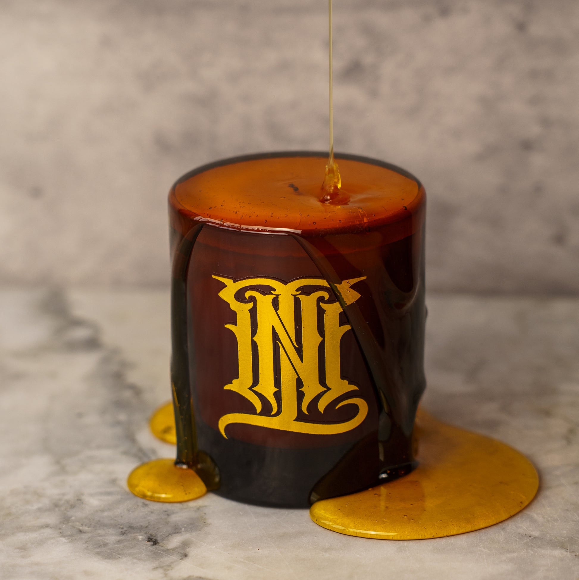 Decorative honey dipper with ornate design on a marble surface