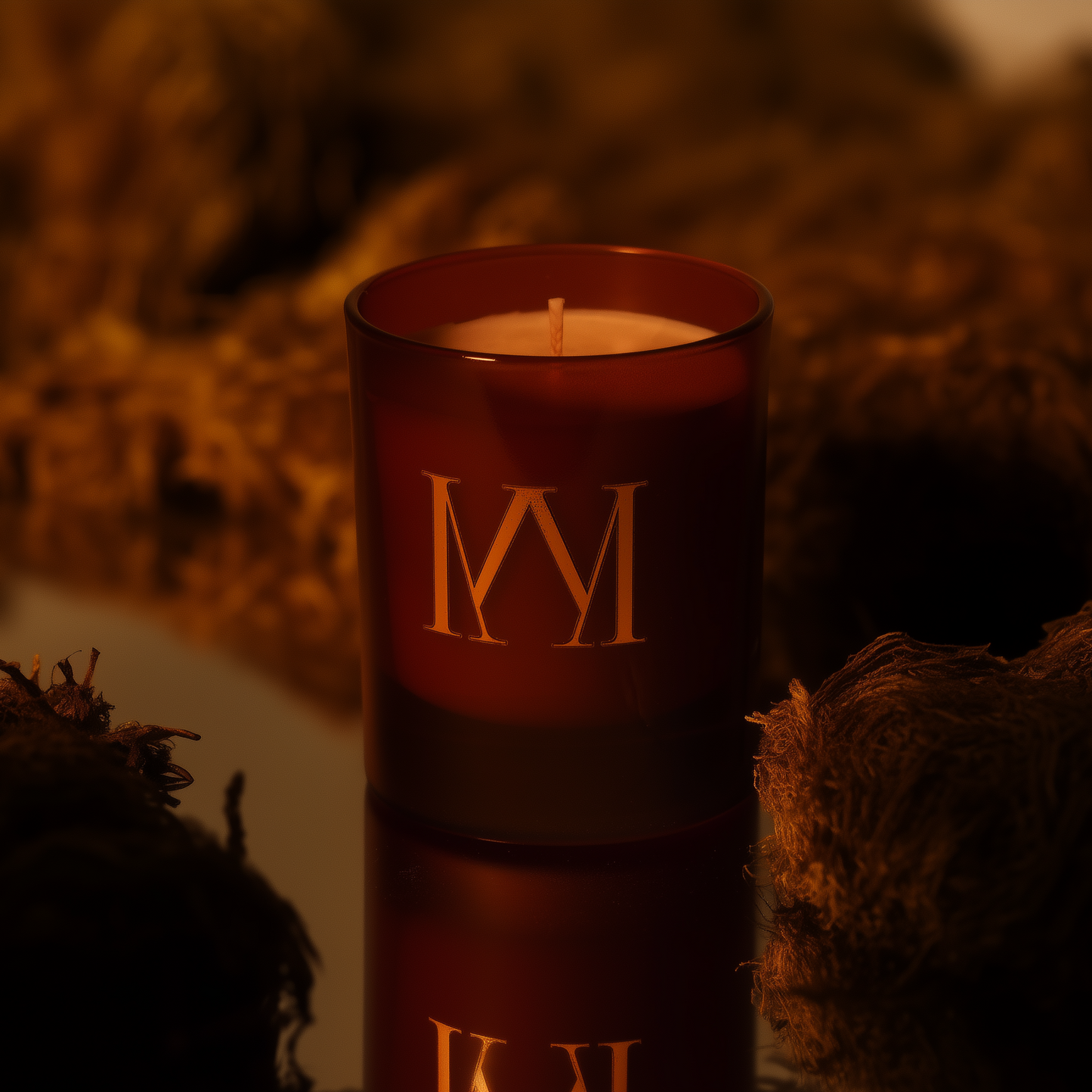 Amber candle with gold lettering on a textured surface