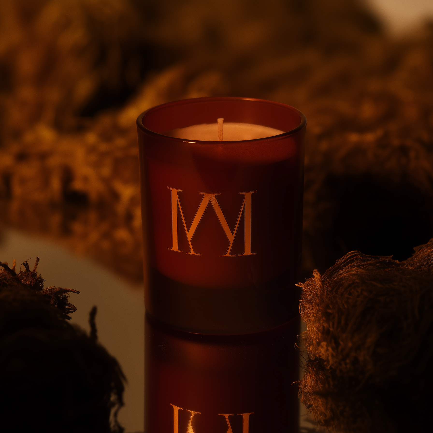 Amber candle with gold lettering on a textured surface