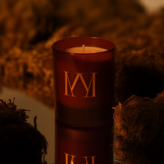 Amber candle with gold lettering on a textured surface